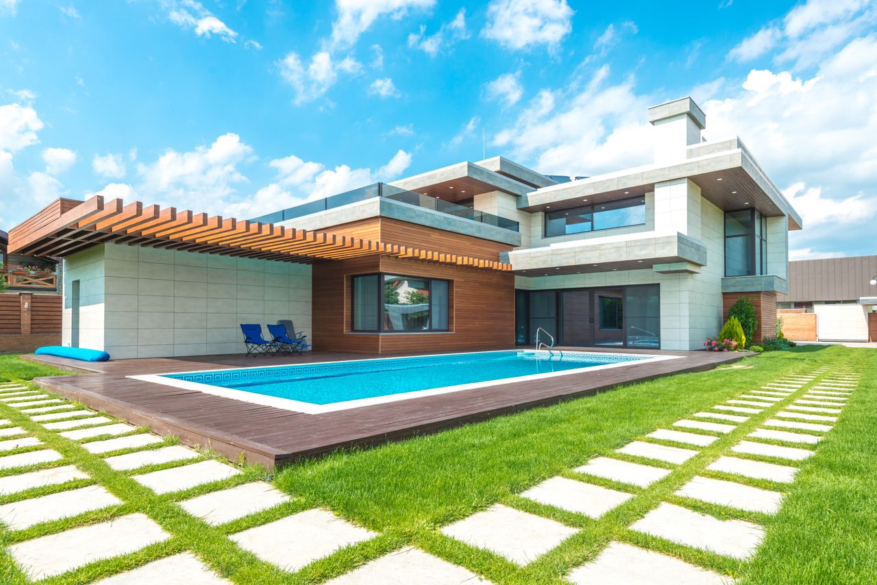 Mastering the First Impression: Your intriguing post title goes here Contemporary house with pool, lush lawn, and clear skies.